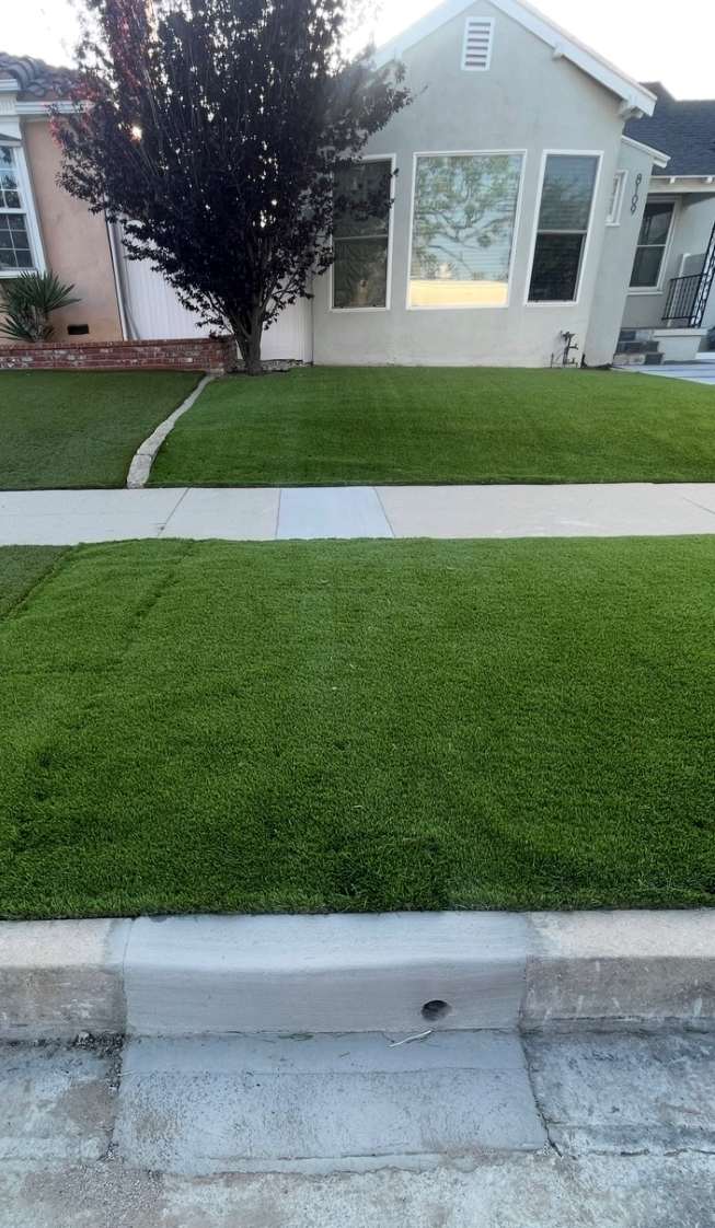 Completed curb drain installation after obtaining a permit for curb drain, showing a finished curb opening and restored landscaping in Los Angeles.