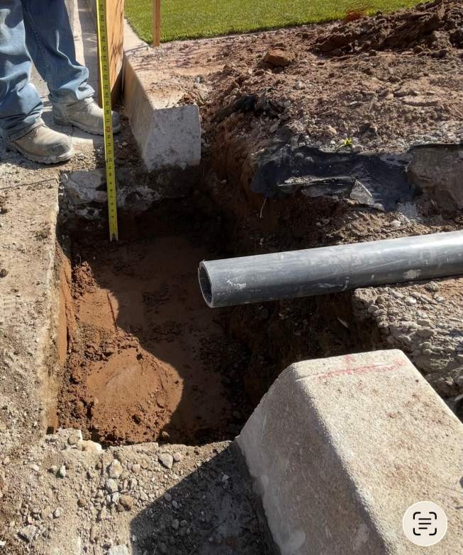 Excavation work for a permit for curb drain showing trench depth, drainage pipe placement, and preparation for installation.