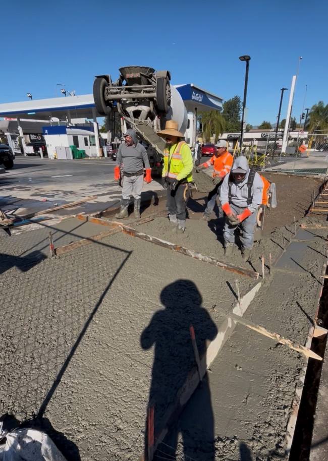 Crew finishing fresh concrete for a permit for new driveway approach ramp at a commercial property, creating a durable and accessible sidewalk